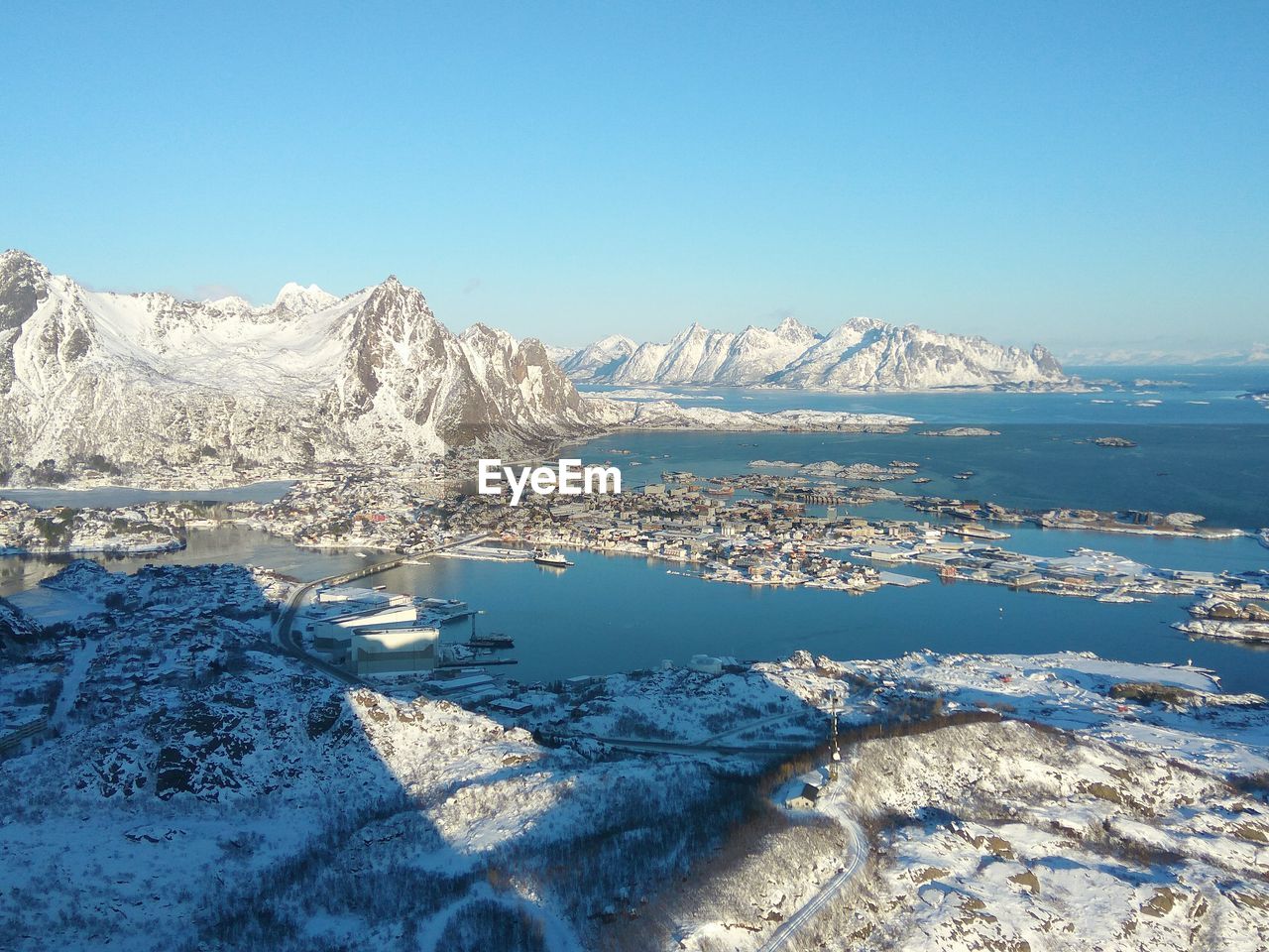 Scenic view of frozen lake against clear blue sky