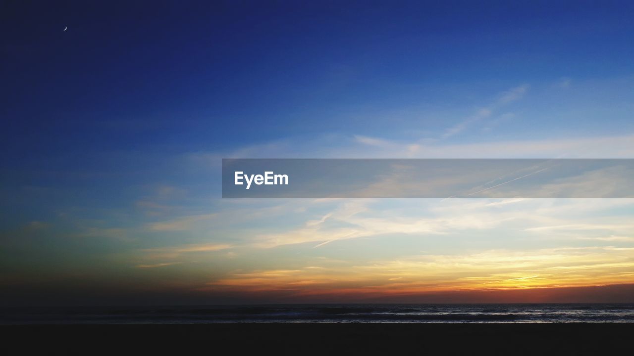 SCENIC VIEW OF SUNSET OVER SEA
