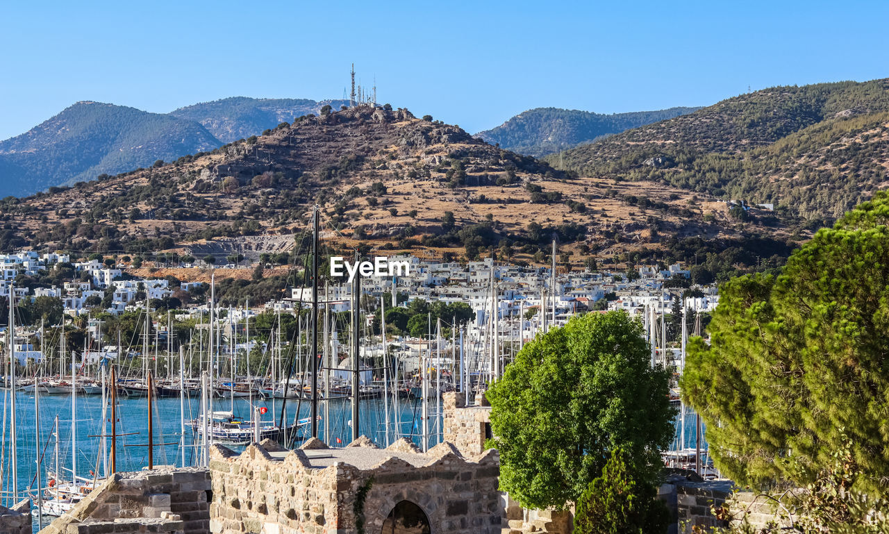 high angle view of townscape by mountain against clear sky