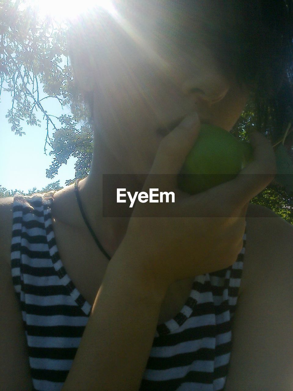 Low angle view of woman eating fruit