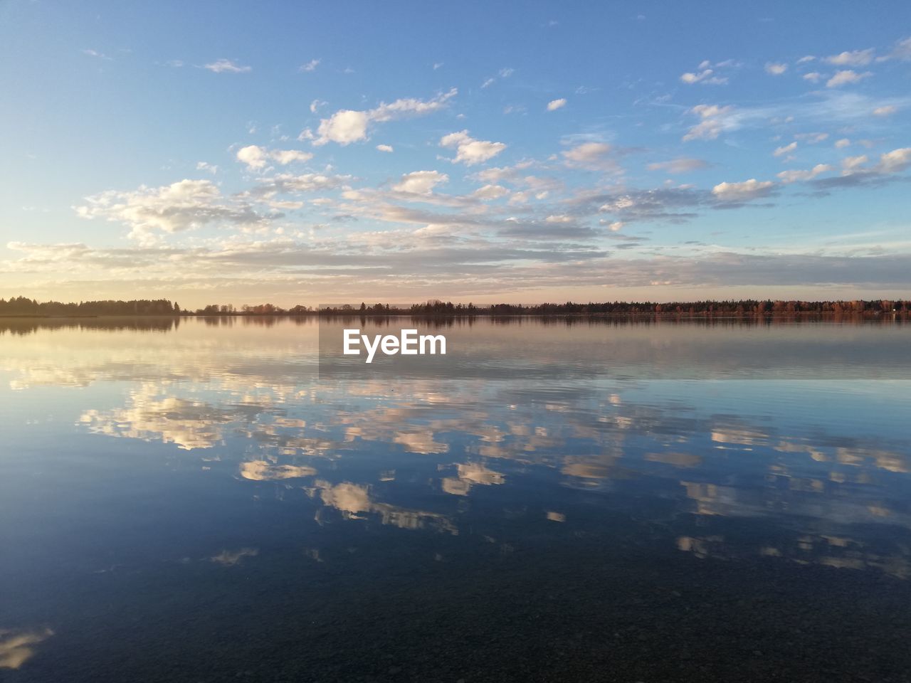 REFLECTION OF CLOUDS IN LAKE AGAINST SKY