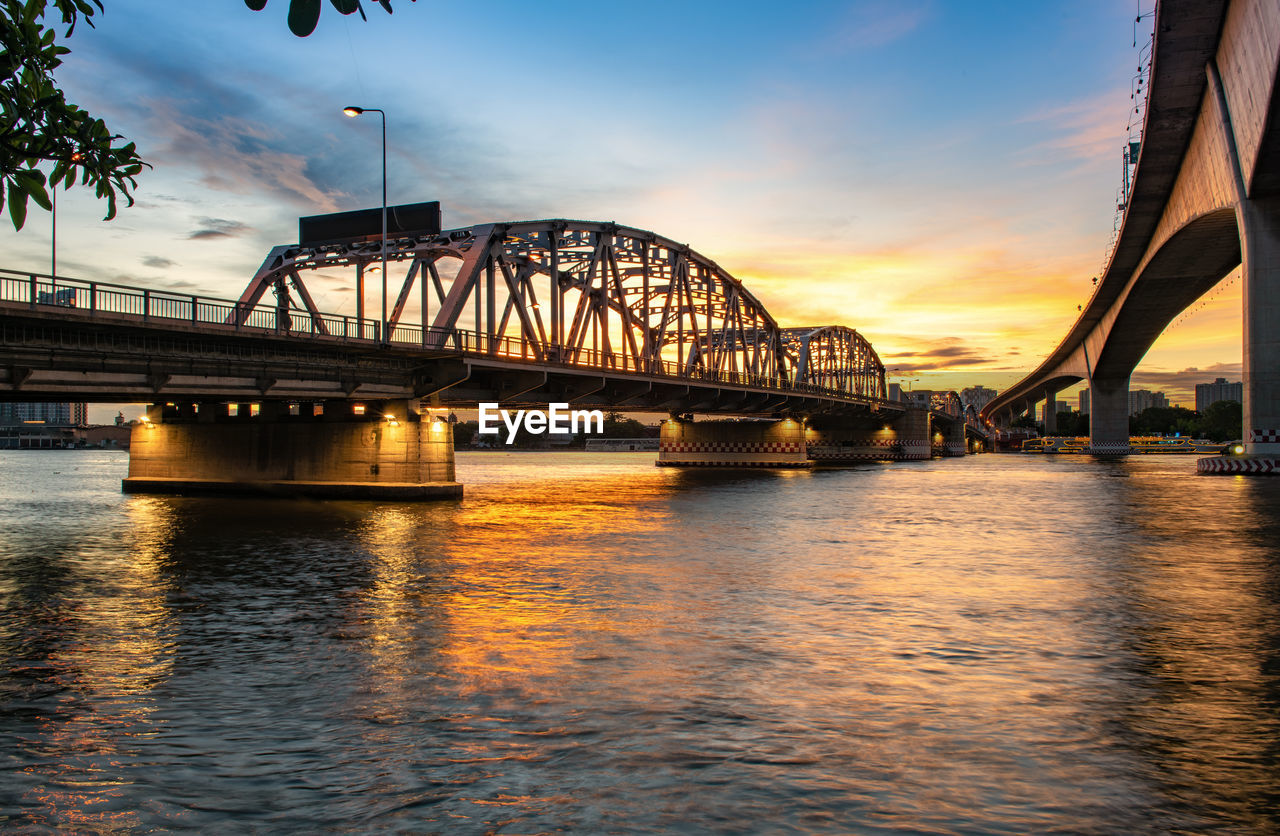 BRIDGE OVER RIVER IN CITY AGAINST SKY