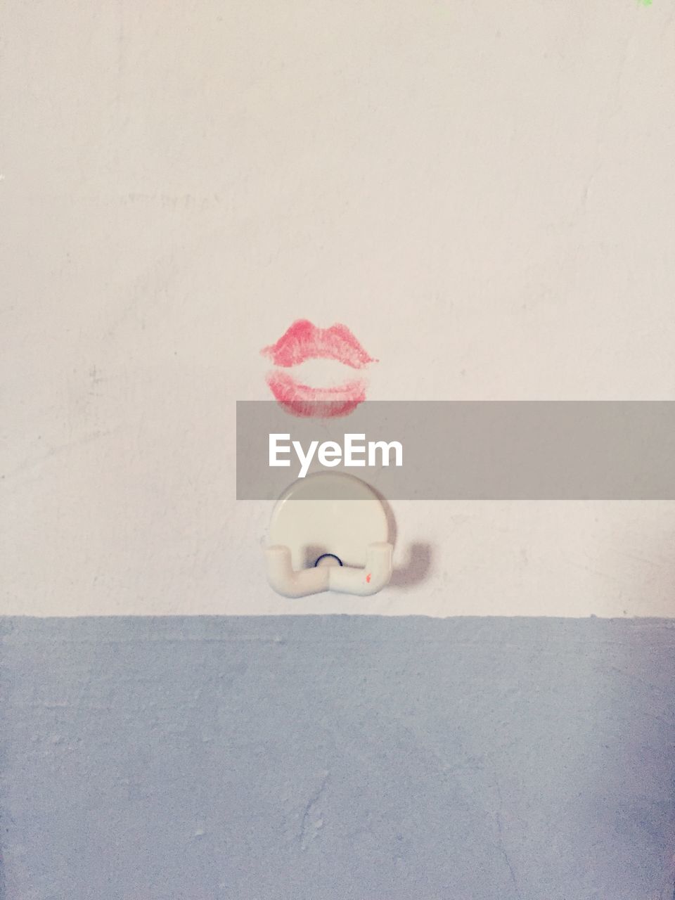 Lipstick kiss above hook on wall