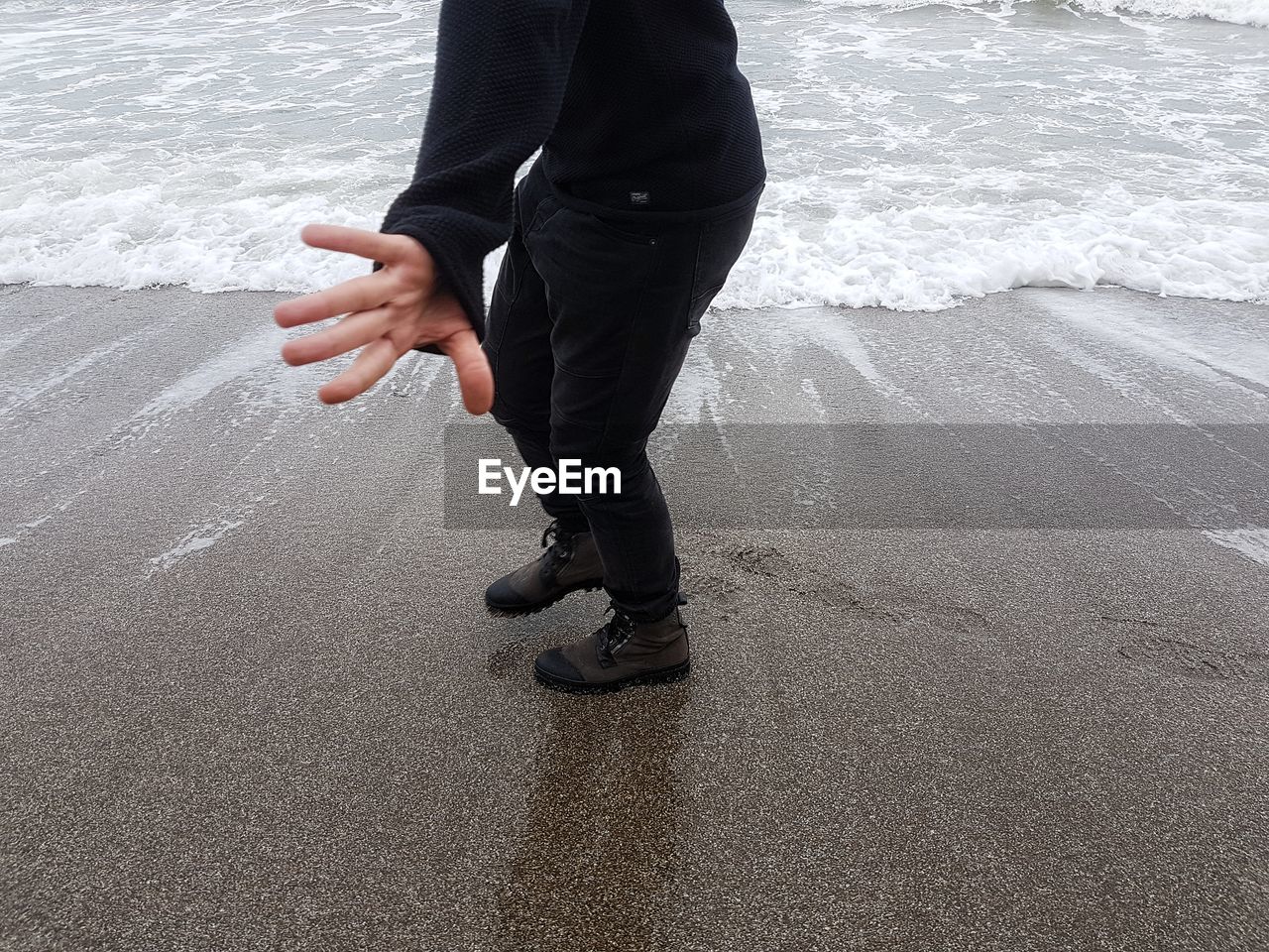 LOW SECTION OF MAN STANDING ON SHORE