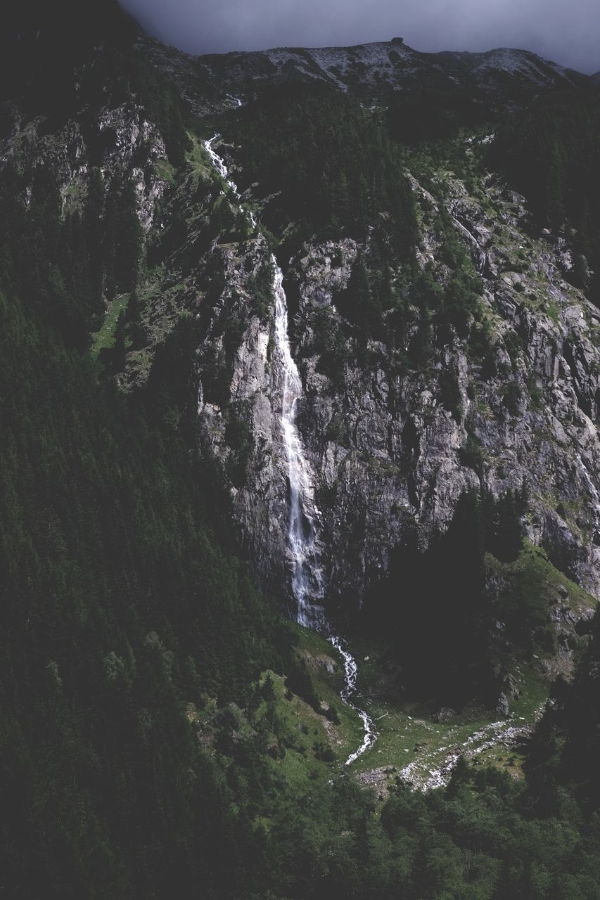 SCENIC VIEW OF WATERFALL IN MOUNTAINS