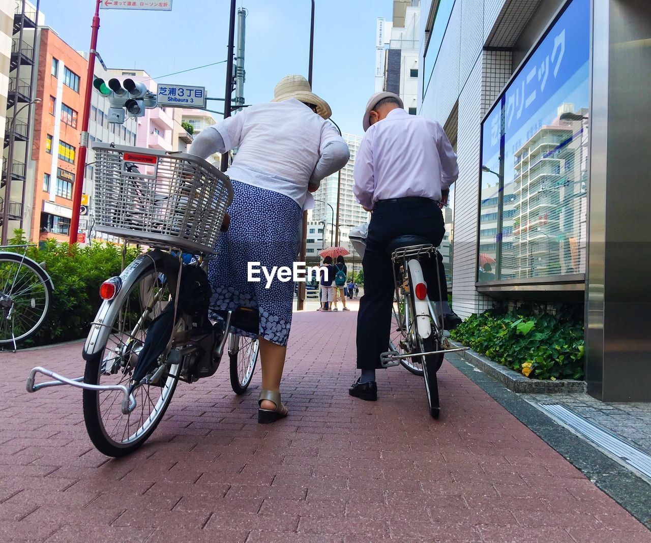 Rear view of people riding bicycles on city street