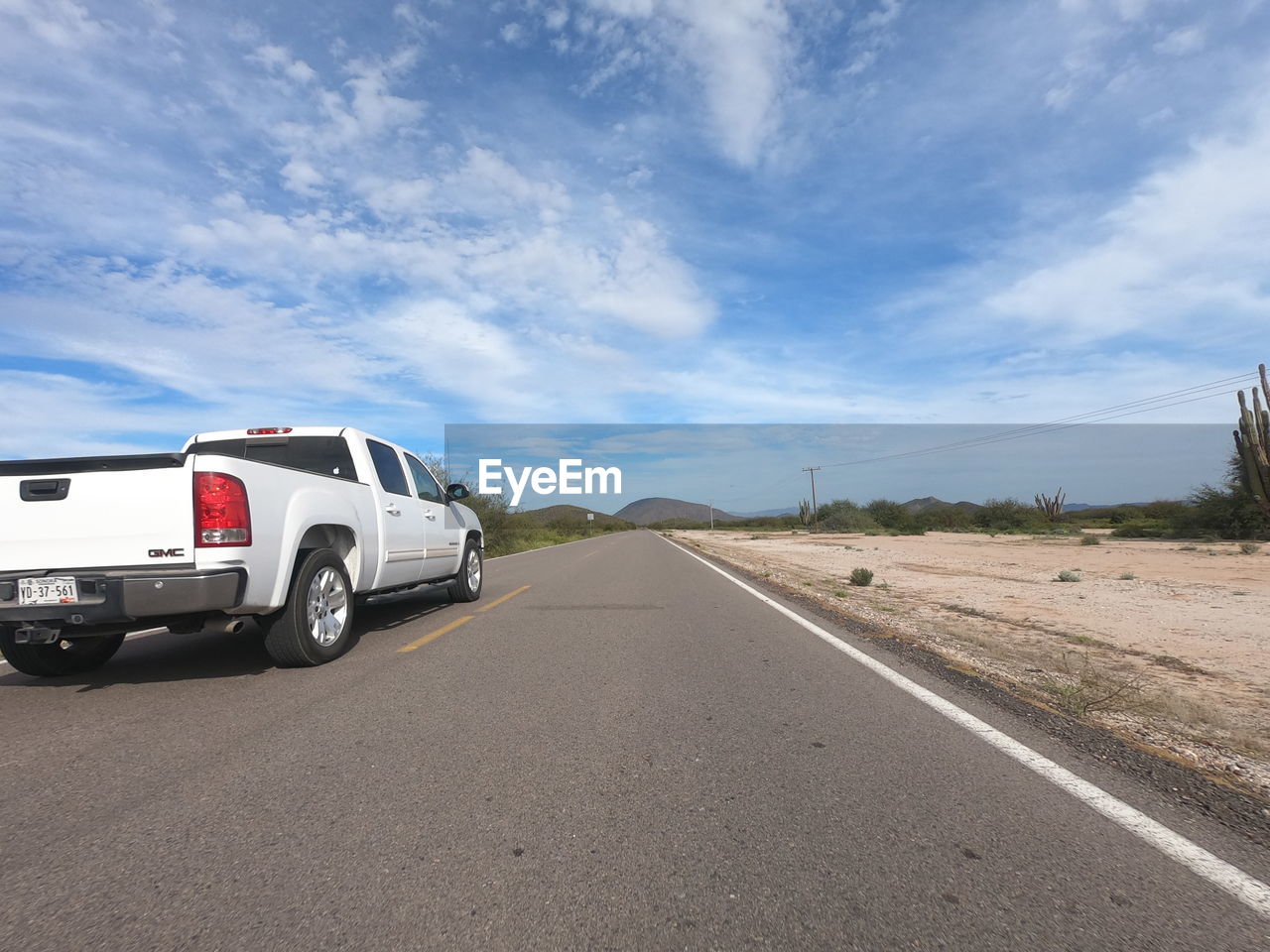 CAR ON ROAD AGAINST SKY