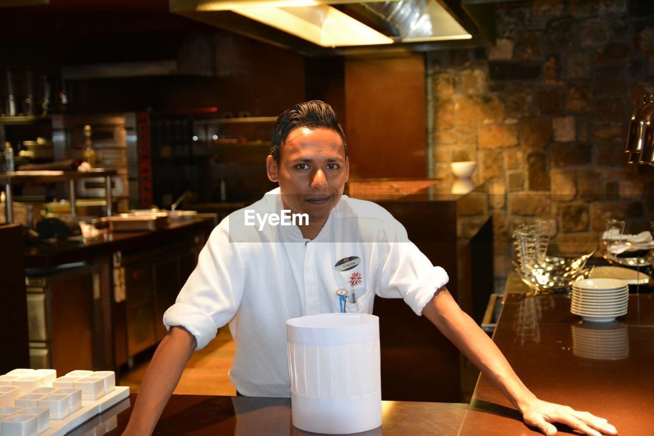 Portrait of young man standing in restaurant