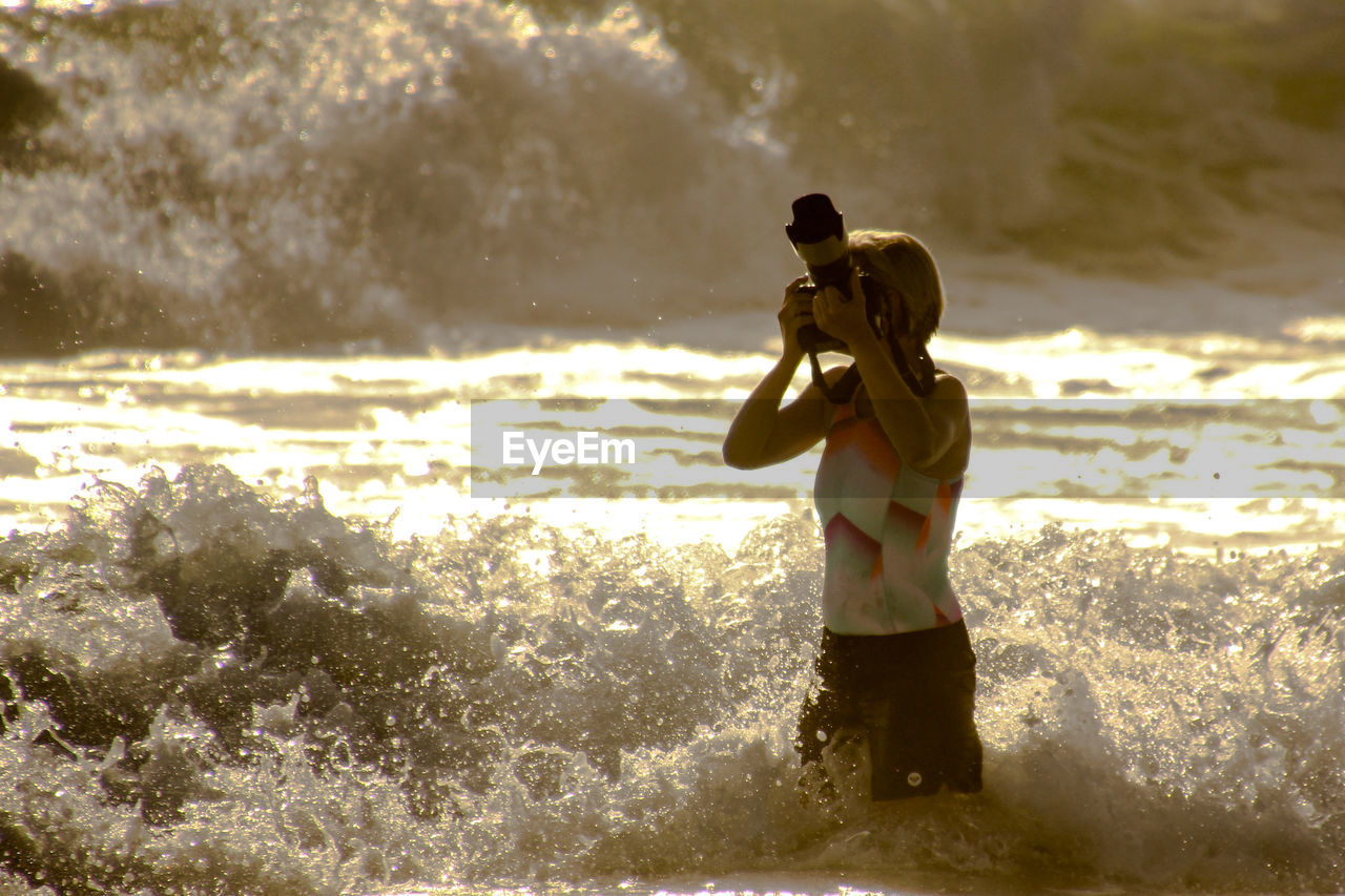 FULL LENGTH OF WOMAN PHOTOGRAPHING ON BEACH