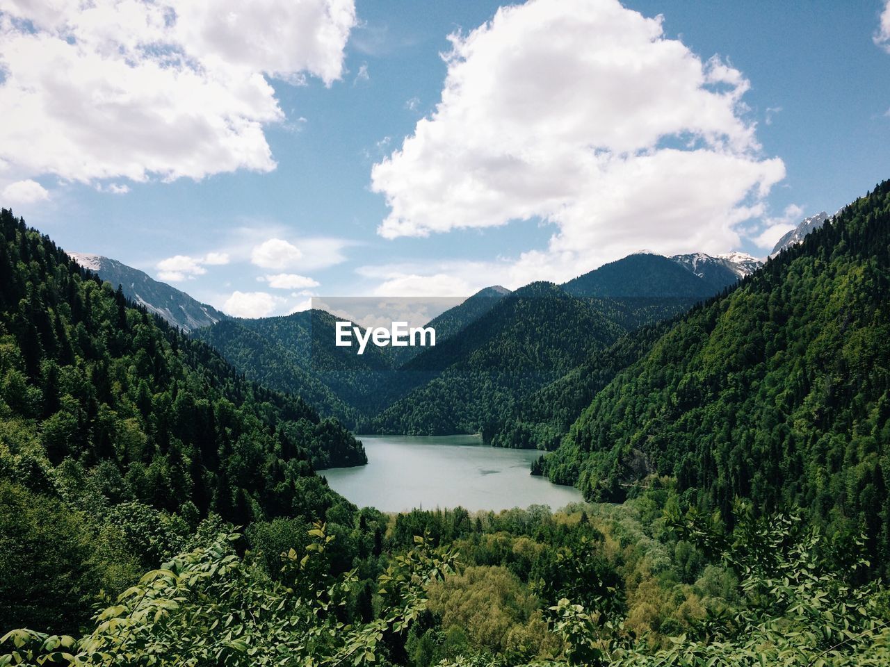 Scenic view of lake amidst tree mountains against sky