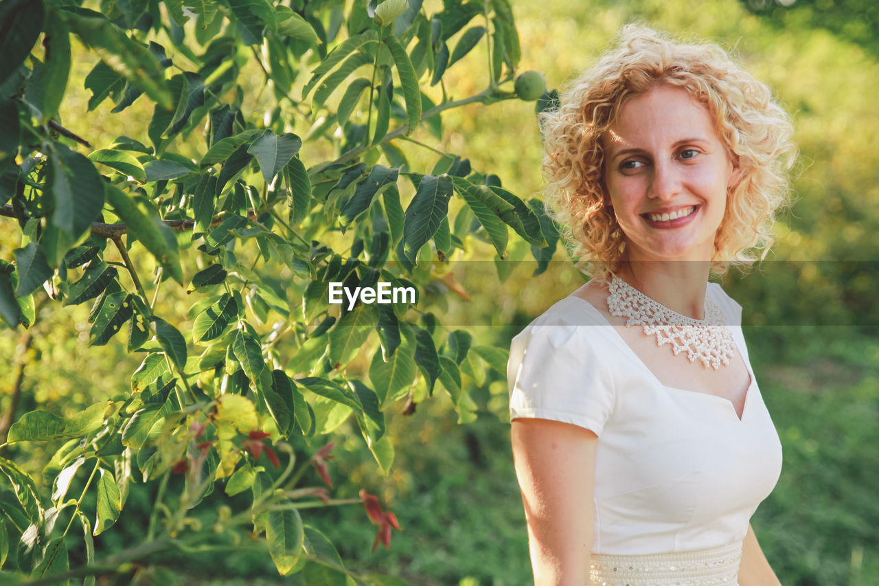 Smiling young woman standing outdoors