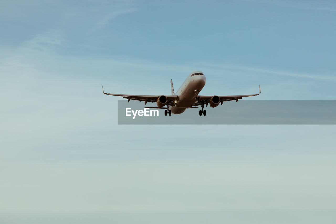 Low angle view of airplane flying against sky