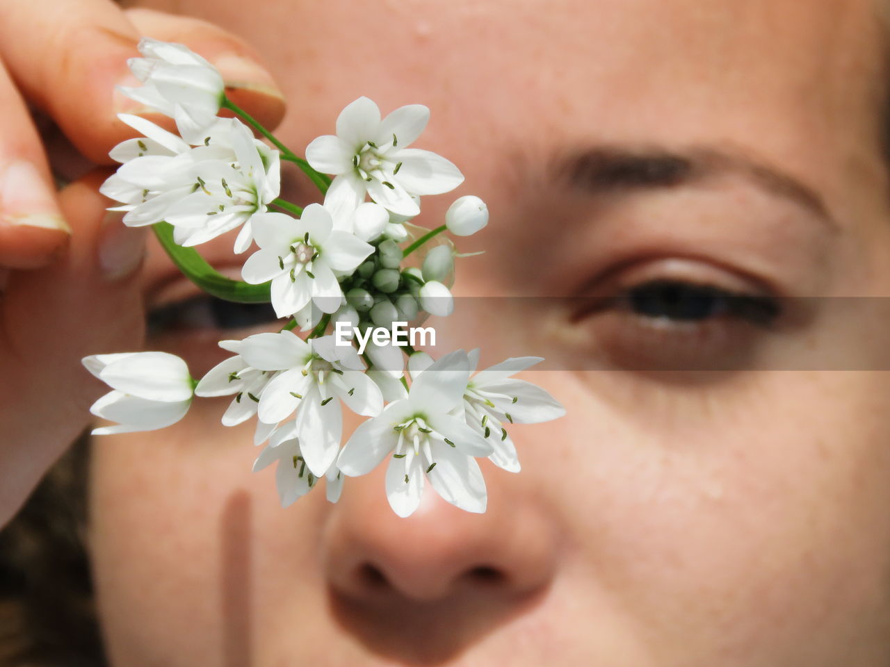 Close-up portrait of woman holding white flowers