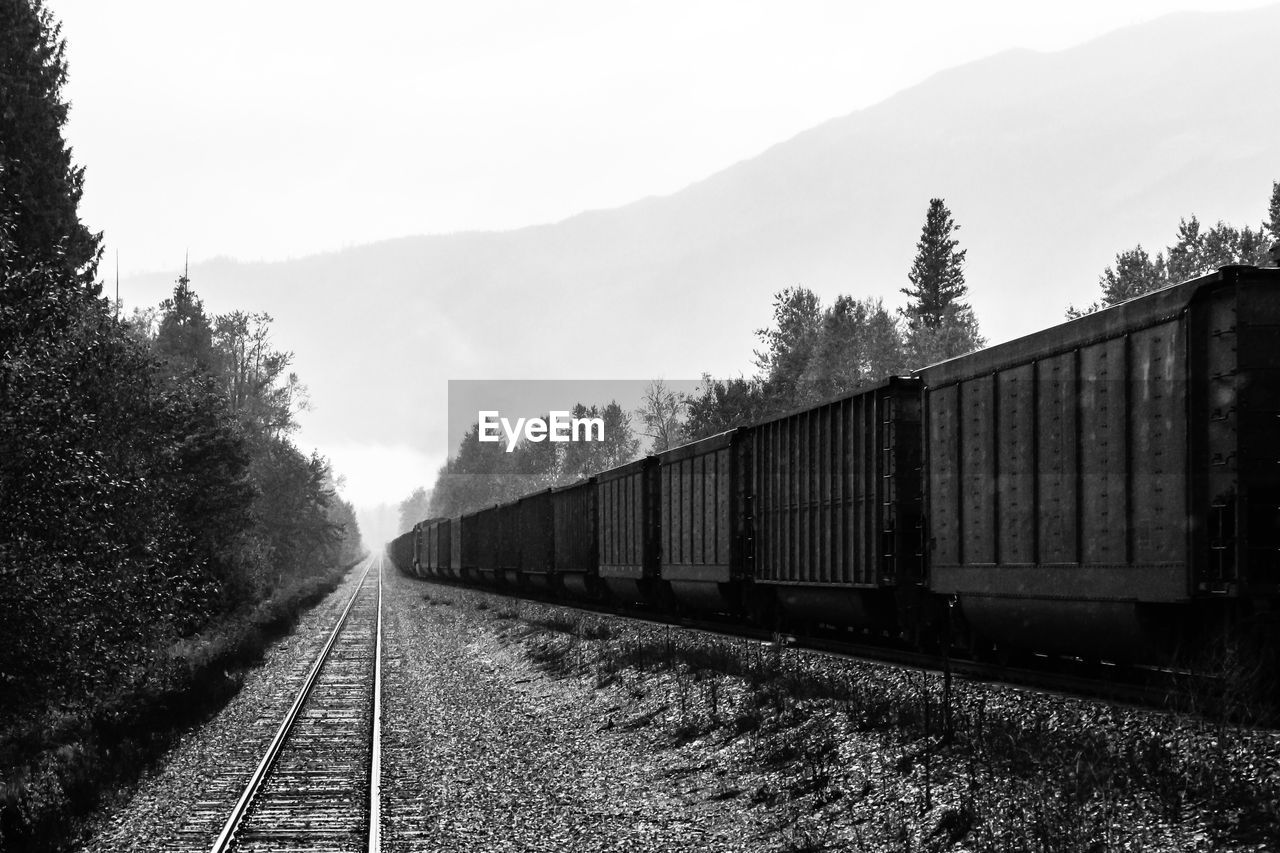 TRAIN ON RAILROAD TRACKS AGAINST SKY