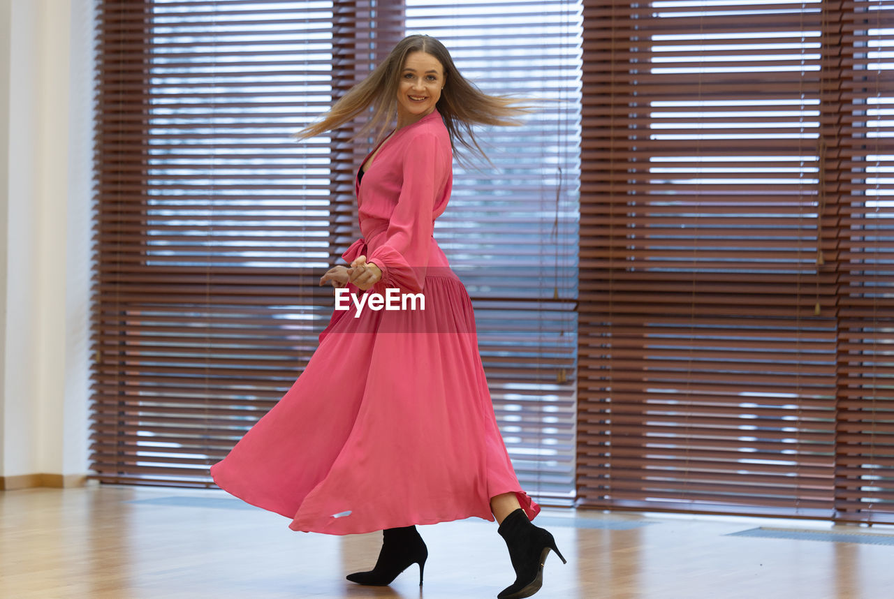 fashion, women, one person, full length, clothing, dress, adult, indoors, gown, elegance, young adult, glamour, spring, portrait, hairstyle, fashion design, red, female, person, standing, arts culture and entertainment, smiling, footwear, lifestyles, long hair, happiness, formal wear, looking at camera