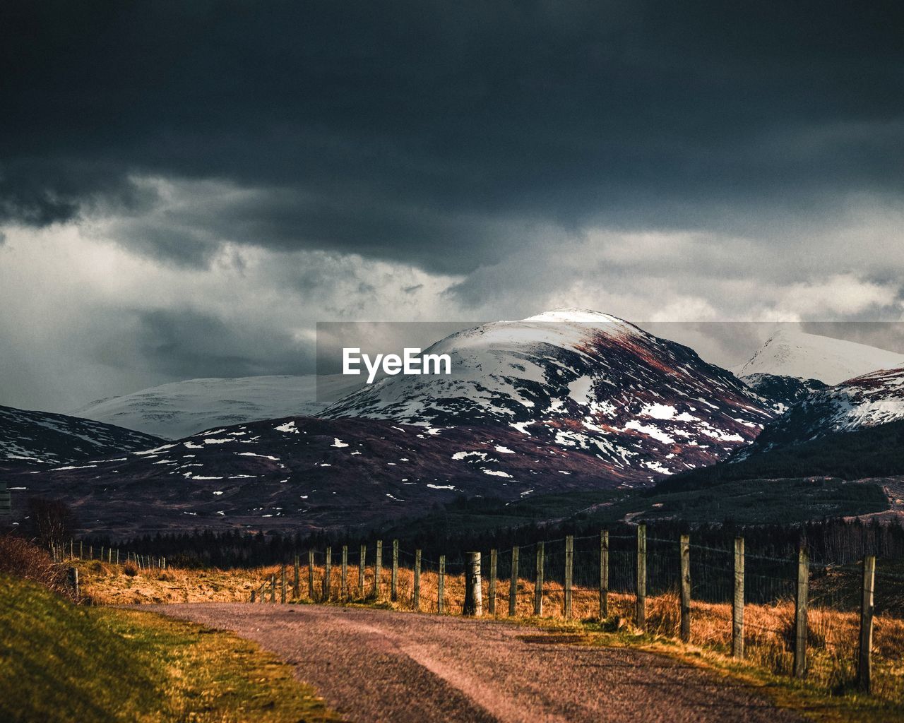 ROAD BY SNOWCAPPED MOUNTAINS AGAINST SKY