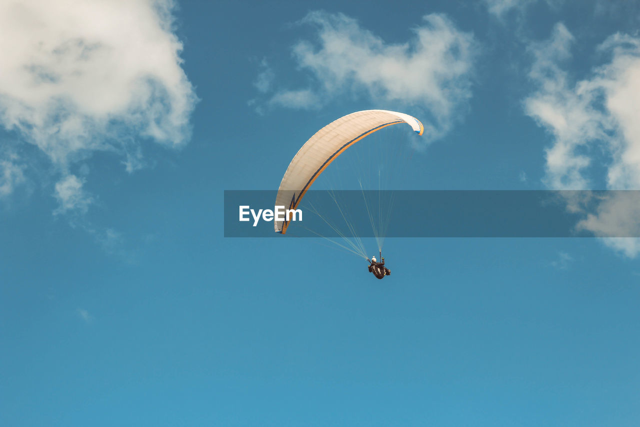 Low angle view of paragliding against sky