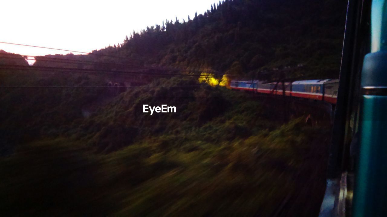 Train passing through mountains during sunset