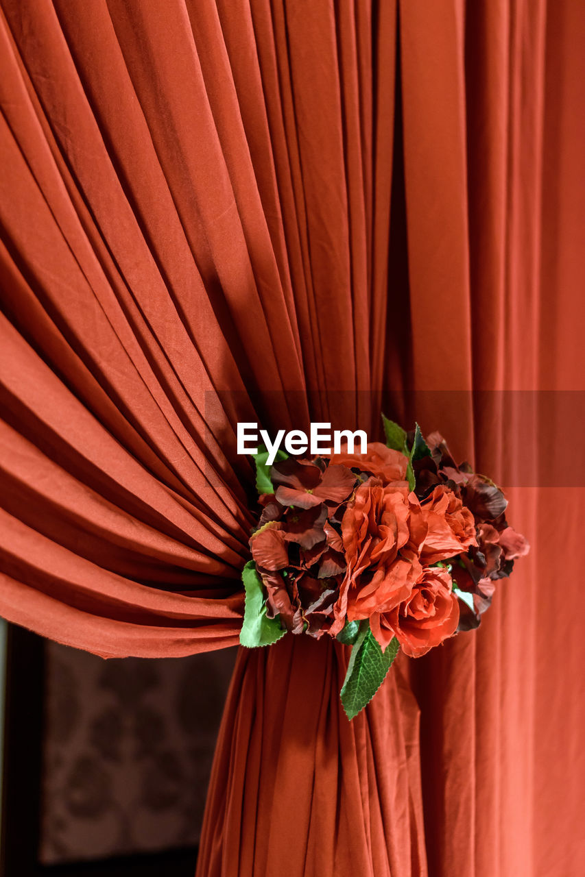 Close-up of red flower on curtain