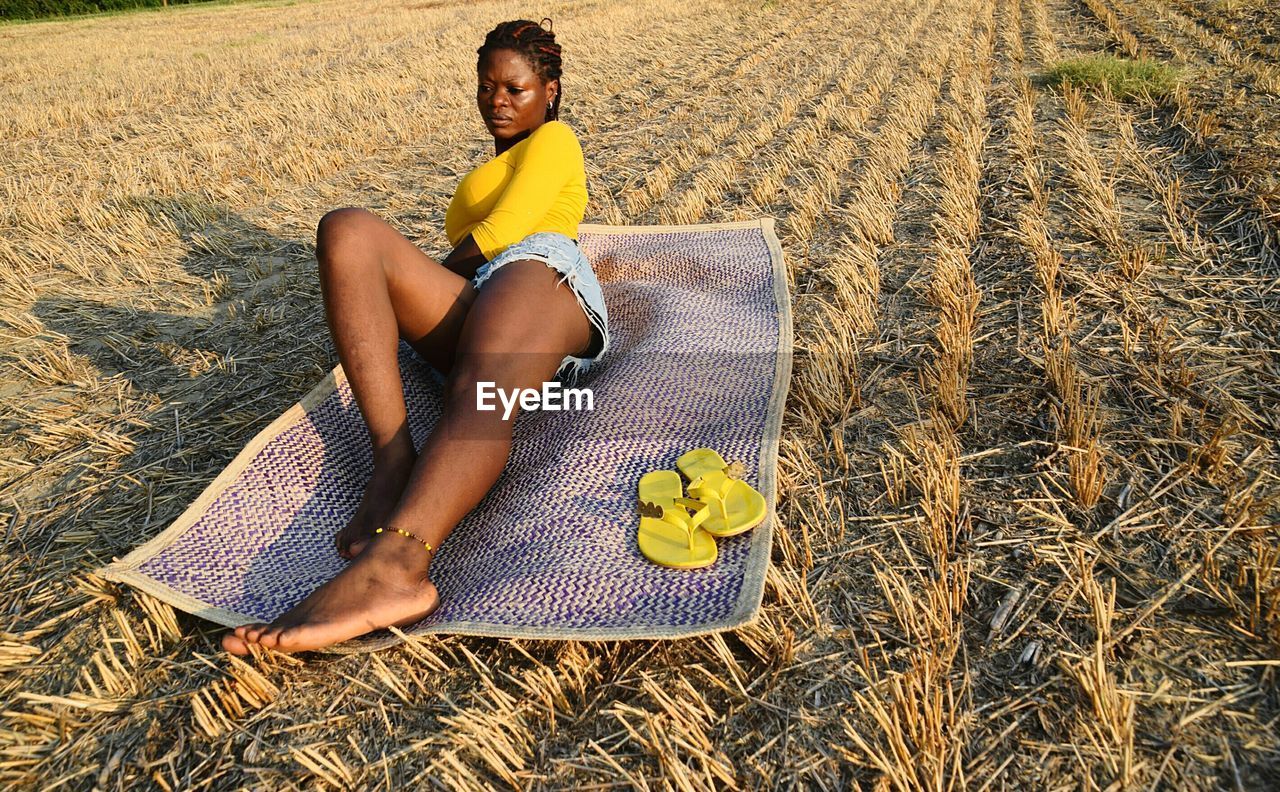 Full length of young woman lying on field