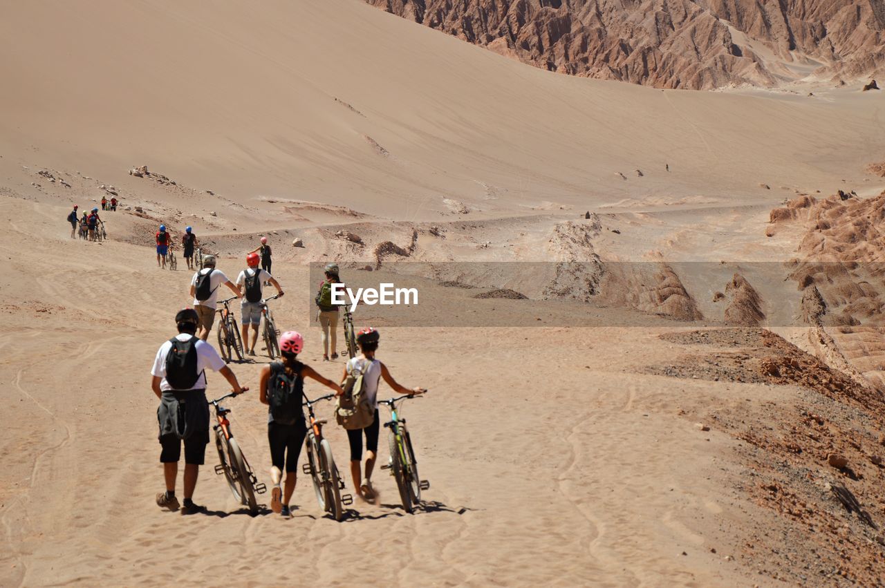 People with bicycles in desert