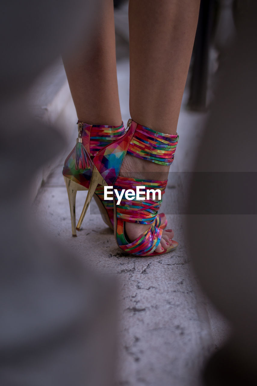 Low section of woman multi colored high heels