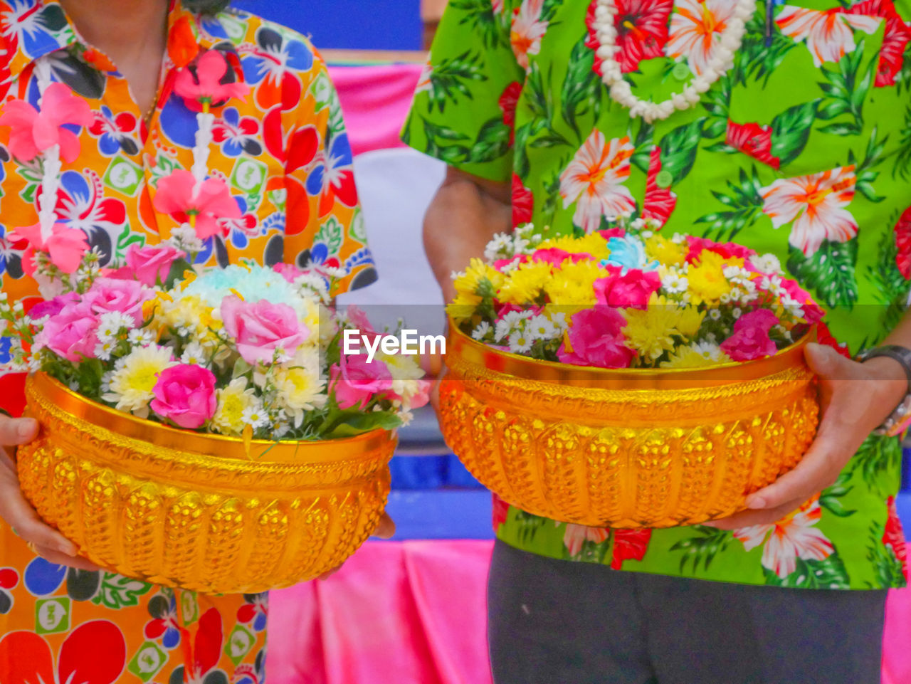 LOW SECTION OF WOMAN HOLDING BOUQUET OF RED FLOWER