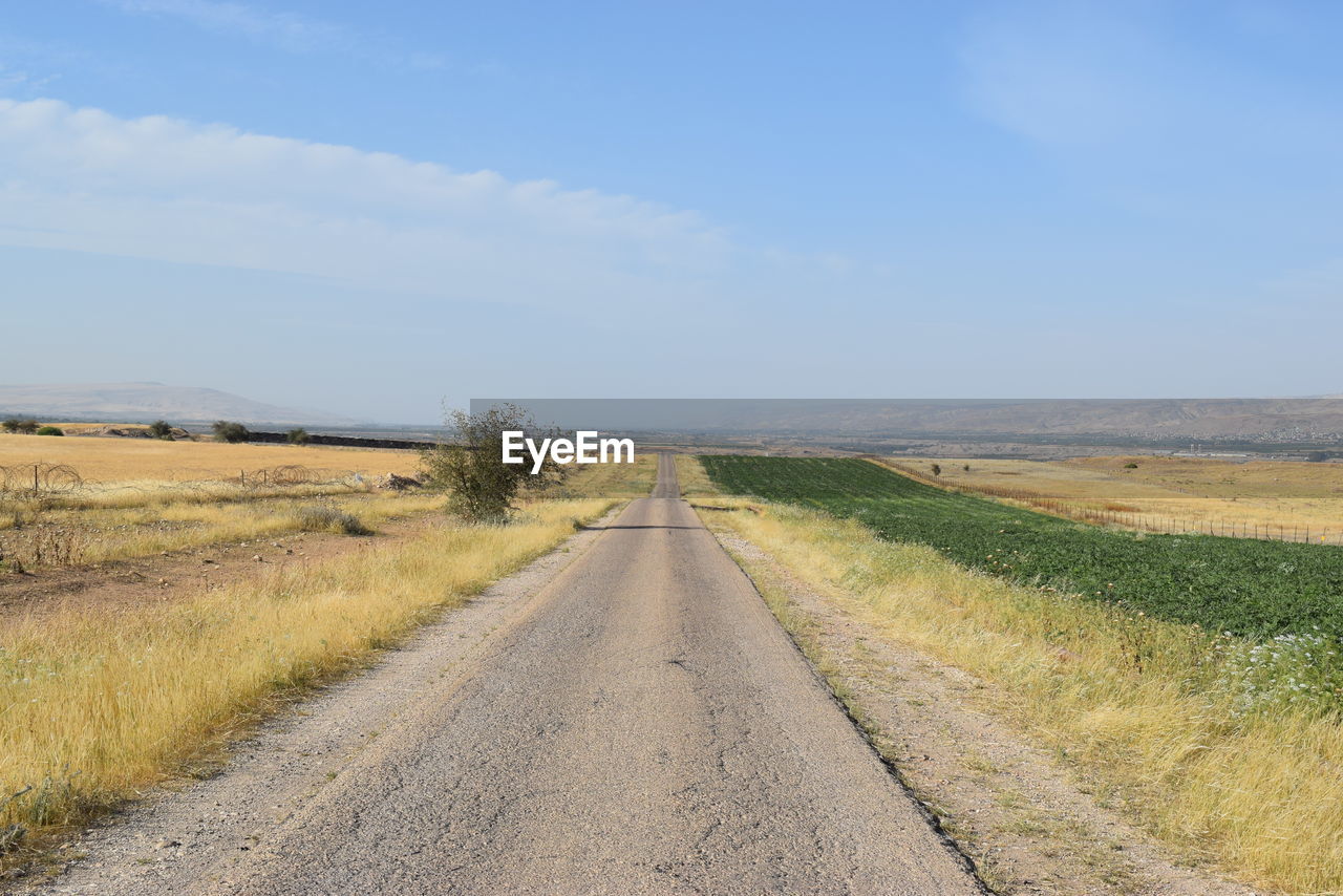 Empty road along countryside landscape