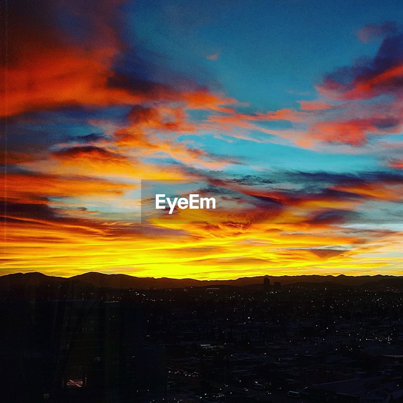 CLOSE-UP OF DRAMATIC SKY OVER SILHOUETTE LANDSCAPE