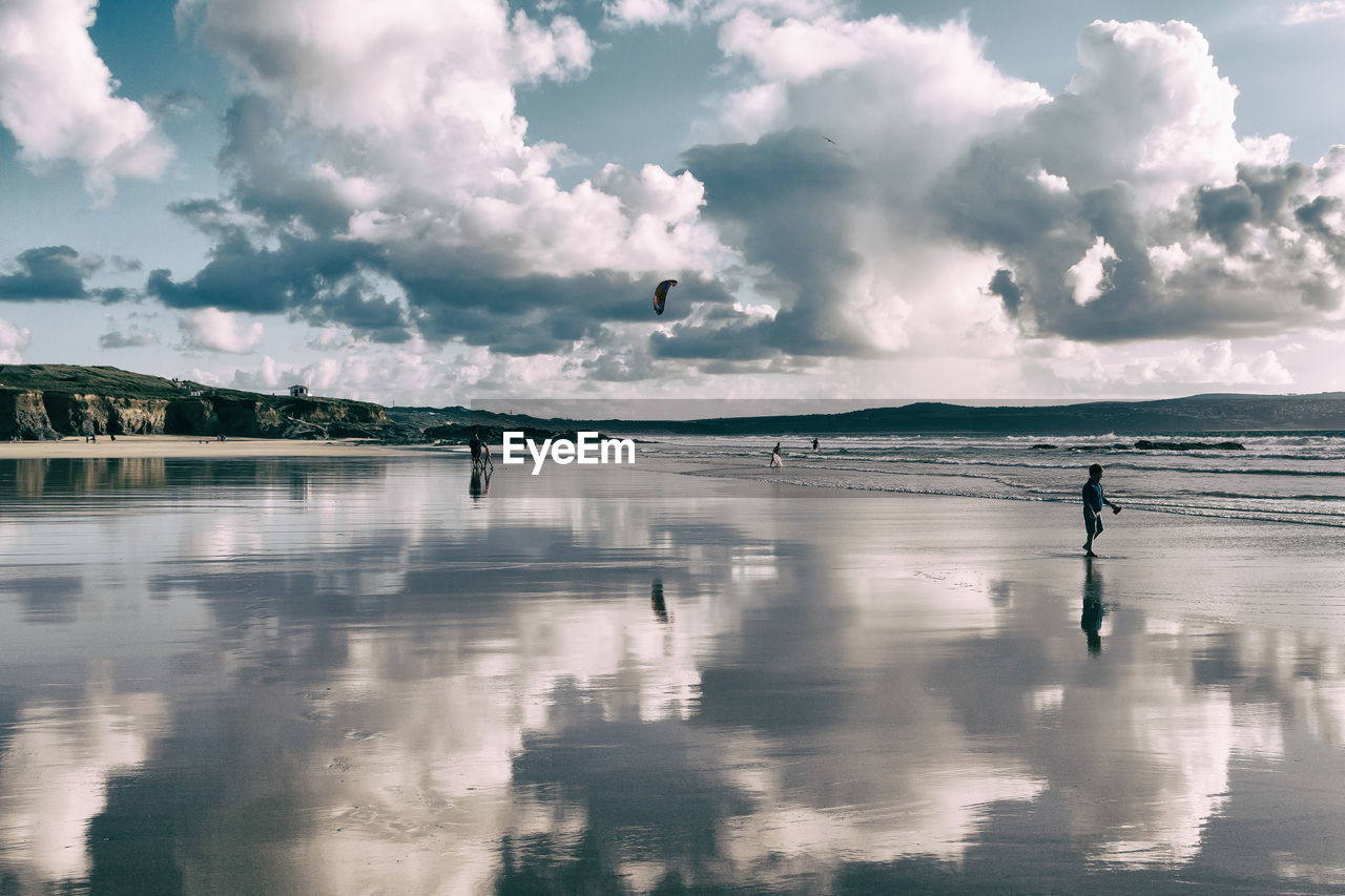 People walking on shore at beach