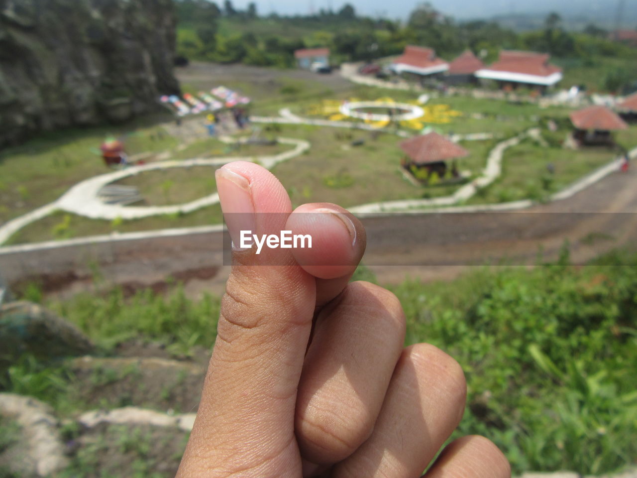 HIGH ANGLE VIEW OF HUMAN HAND HOLDING SMALL OUTDOORS