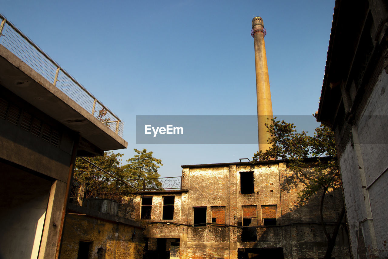 LOW ANGLE VIEW OF ABANDONED BUILDING AGAINST CLEAR SKY