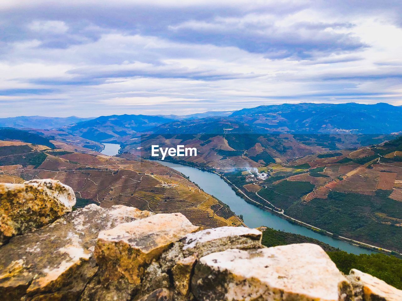 Scenic view of river by mountains against sky