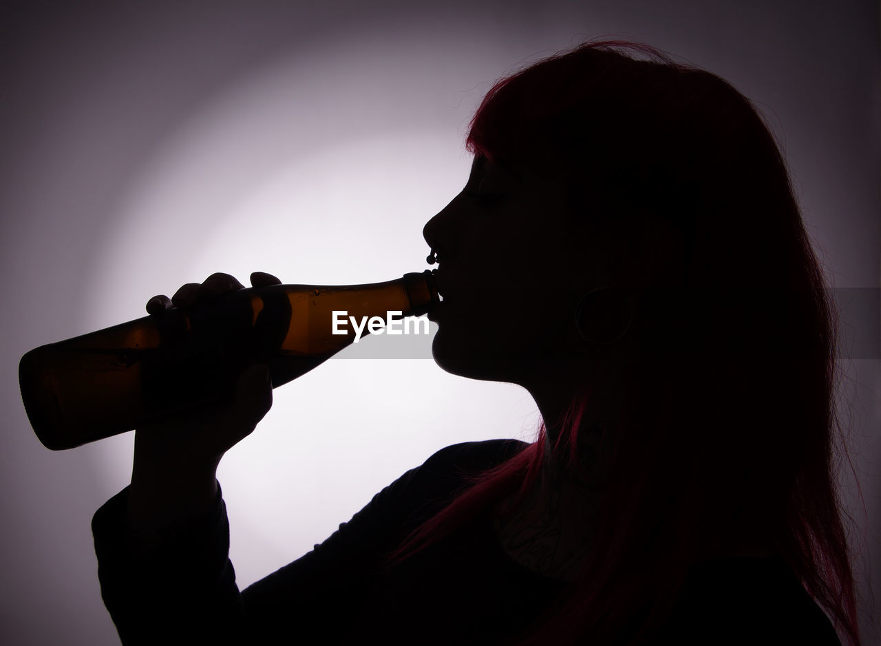 Side view of silhouette woman having drink