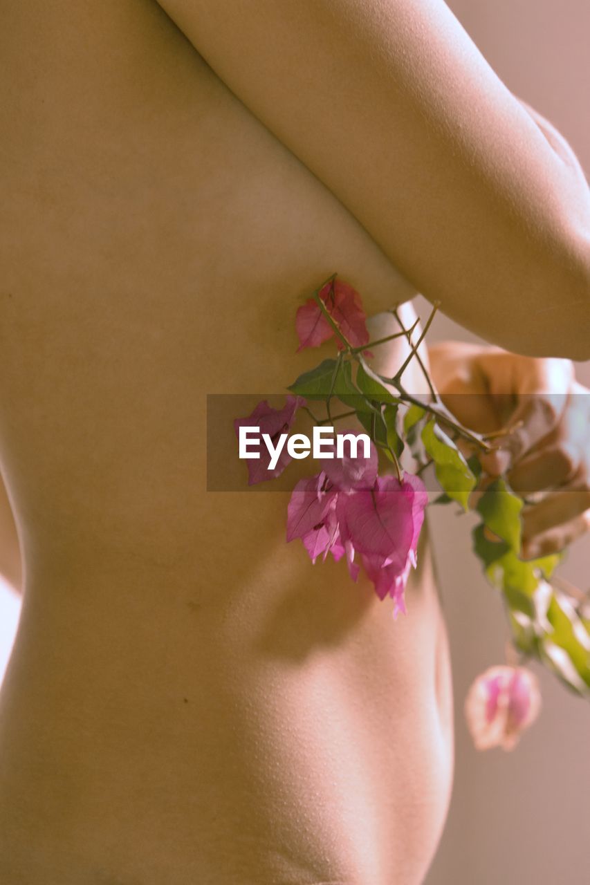 Midsection of woman with flowers