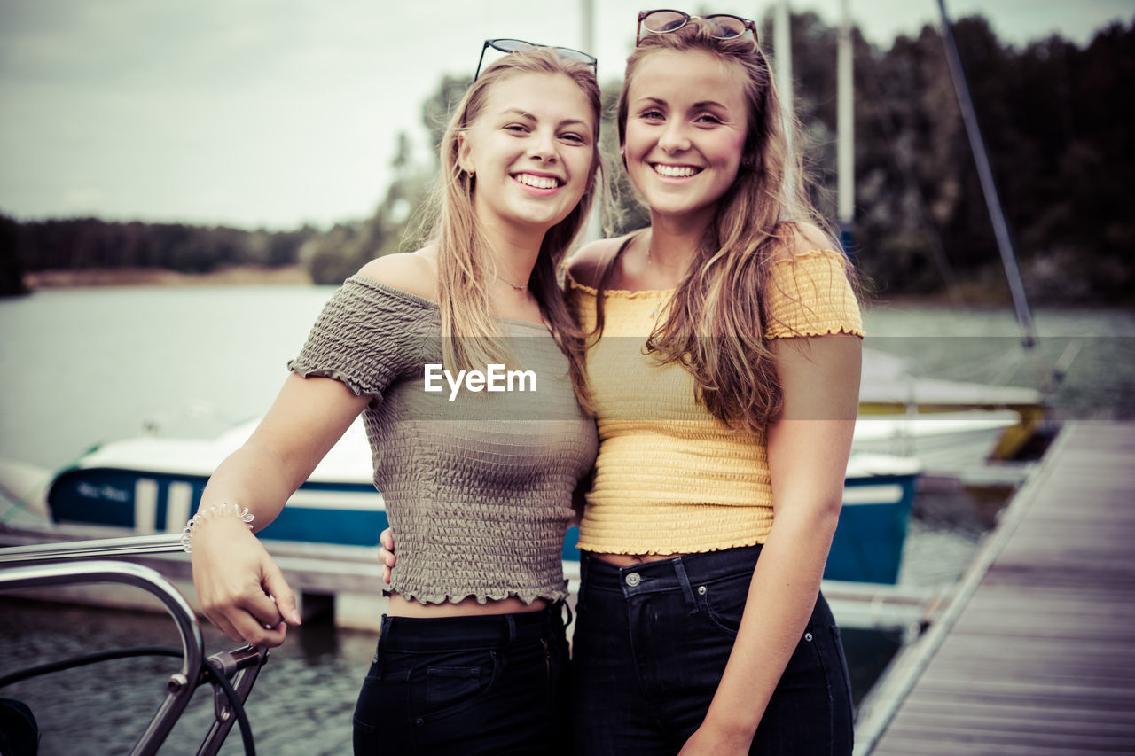 FULL LENGTH OF SMILING YOUNG WOMAN IN BOAT