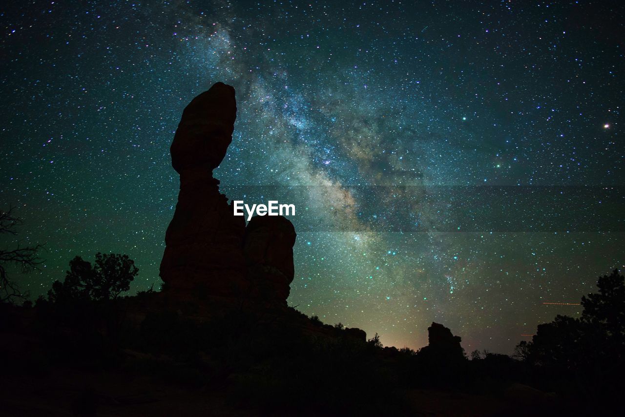 Scenic view of silhouette rock formation against star field at night