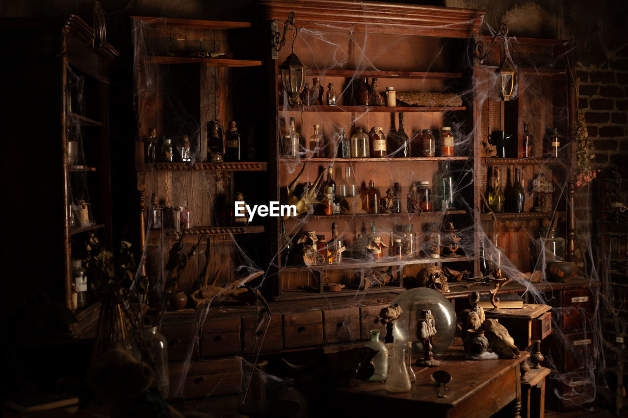 Bottles on shelf with spider web