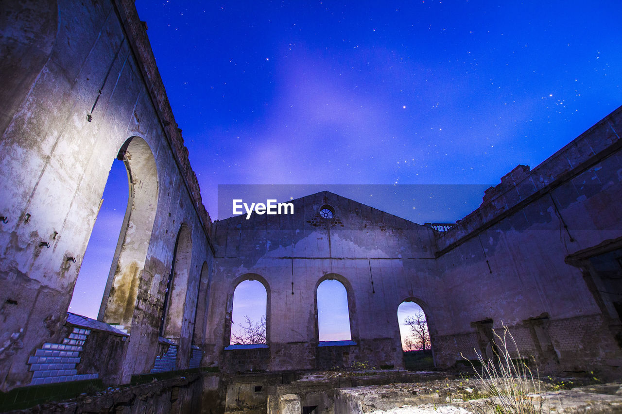 Low angle view of blue sky at night in abandoned building