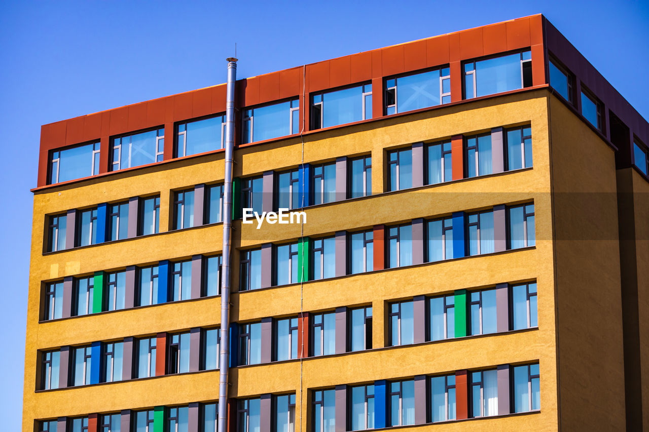 Beautiful view of the front facade of a colorful building with a red roof