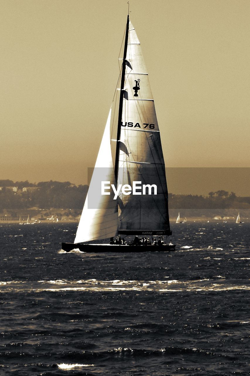 Sailboat in sea against clear sky