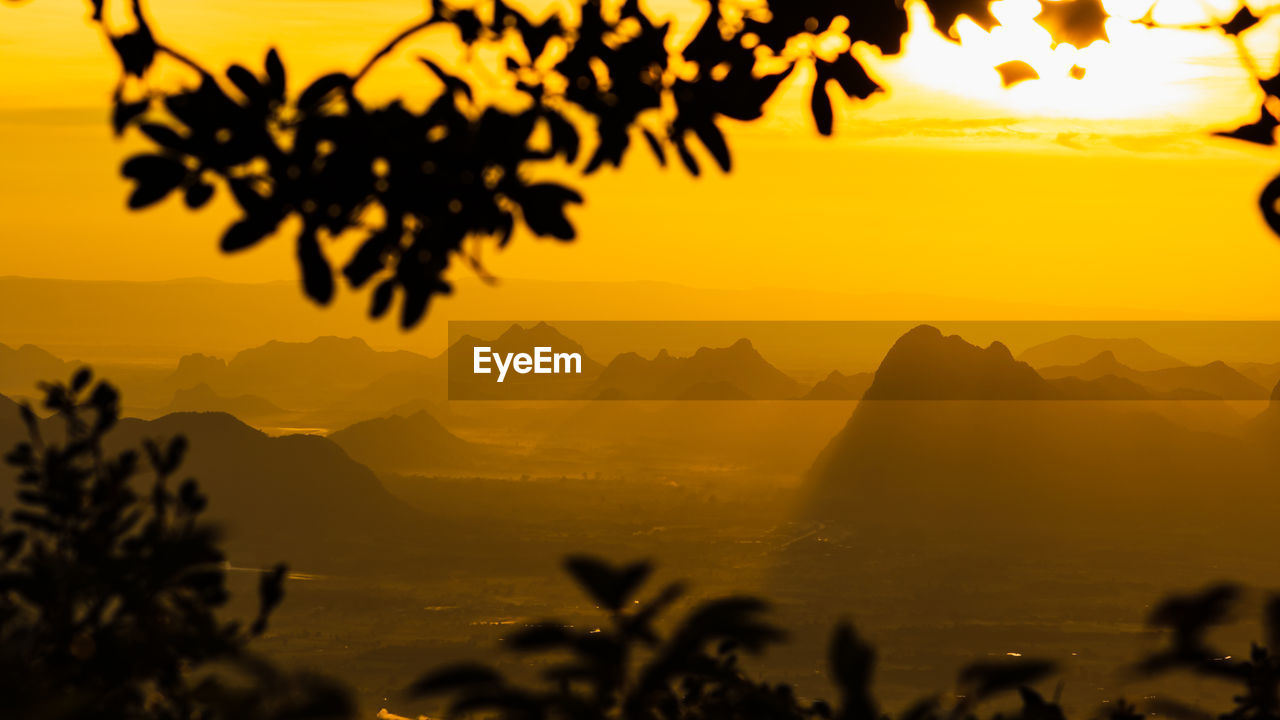 SCENIC VIEW OF SILHOUETTE MOUNTAINS AND TREES AGAINST SKY DURING SUNSET