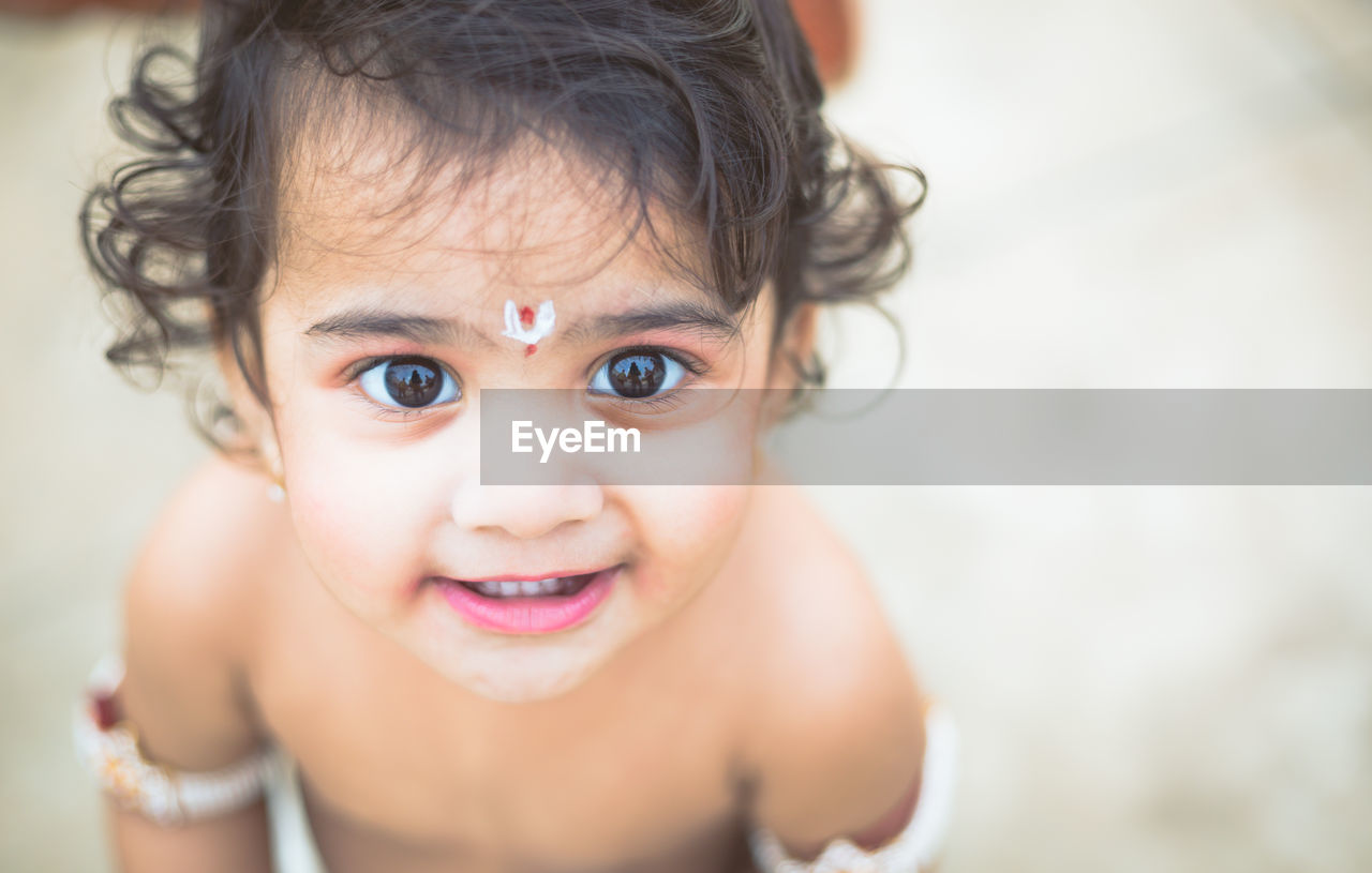 High angle portrait of cute shirtless girl standing outdoors