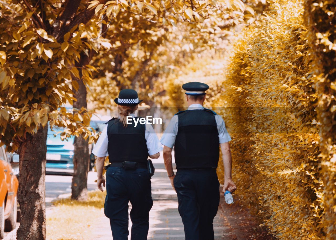 Rear view of two people walking in autumn