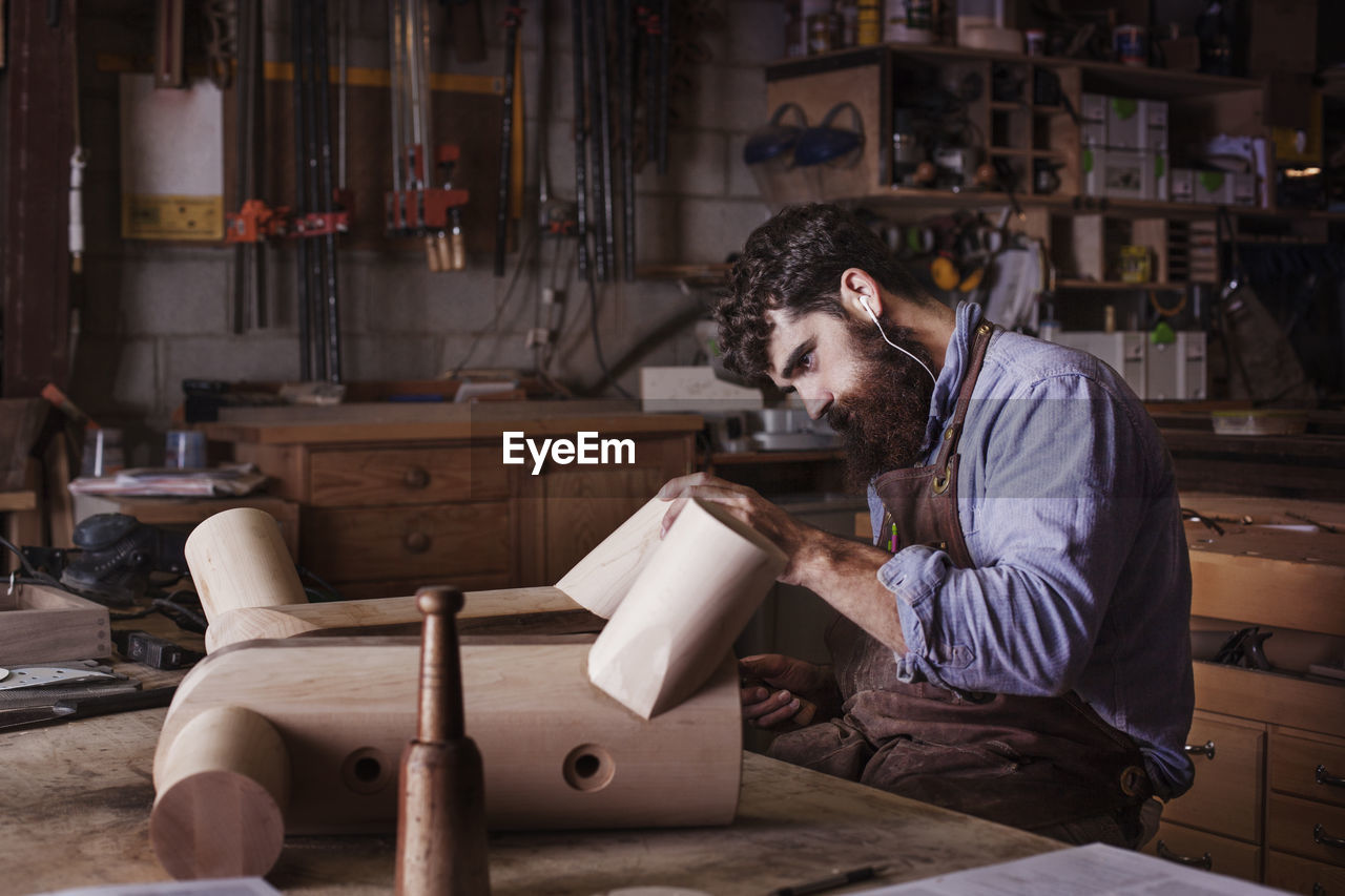 Carpenter making wooden furniture at workshop