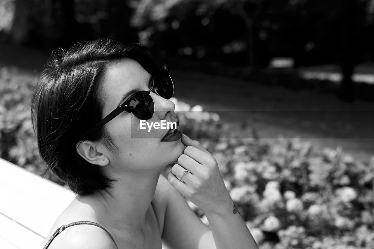 CLOSE-UP PORTRAIT OF WOMAN WEARING SUNGLASSES