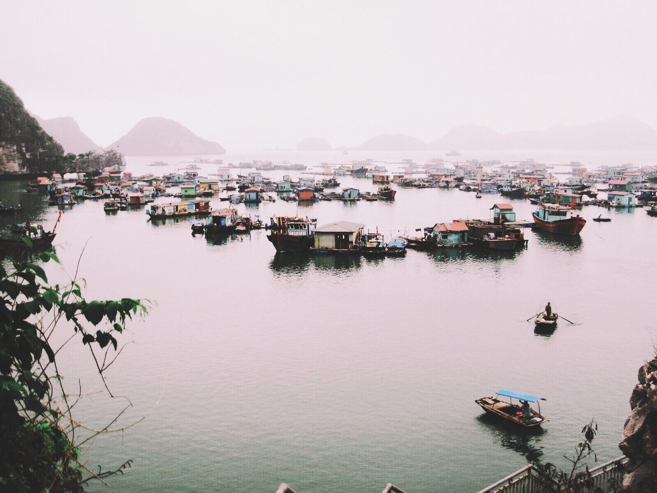 Boats moored in sea against sky during foggy weather