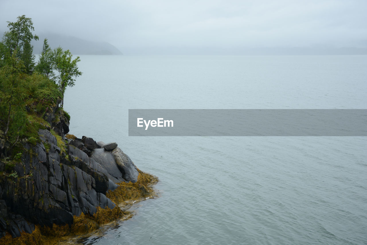 Scenic view of rocks in sea against sky