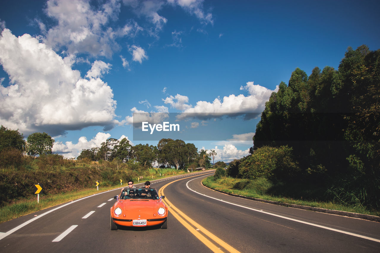 VEHICLES ON ROAD AGAINST SKY