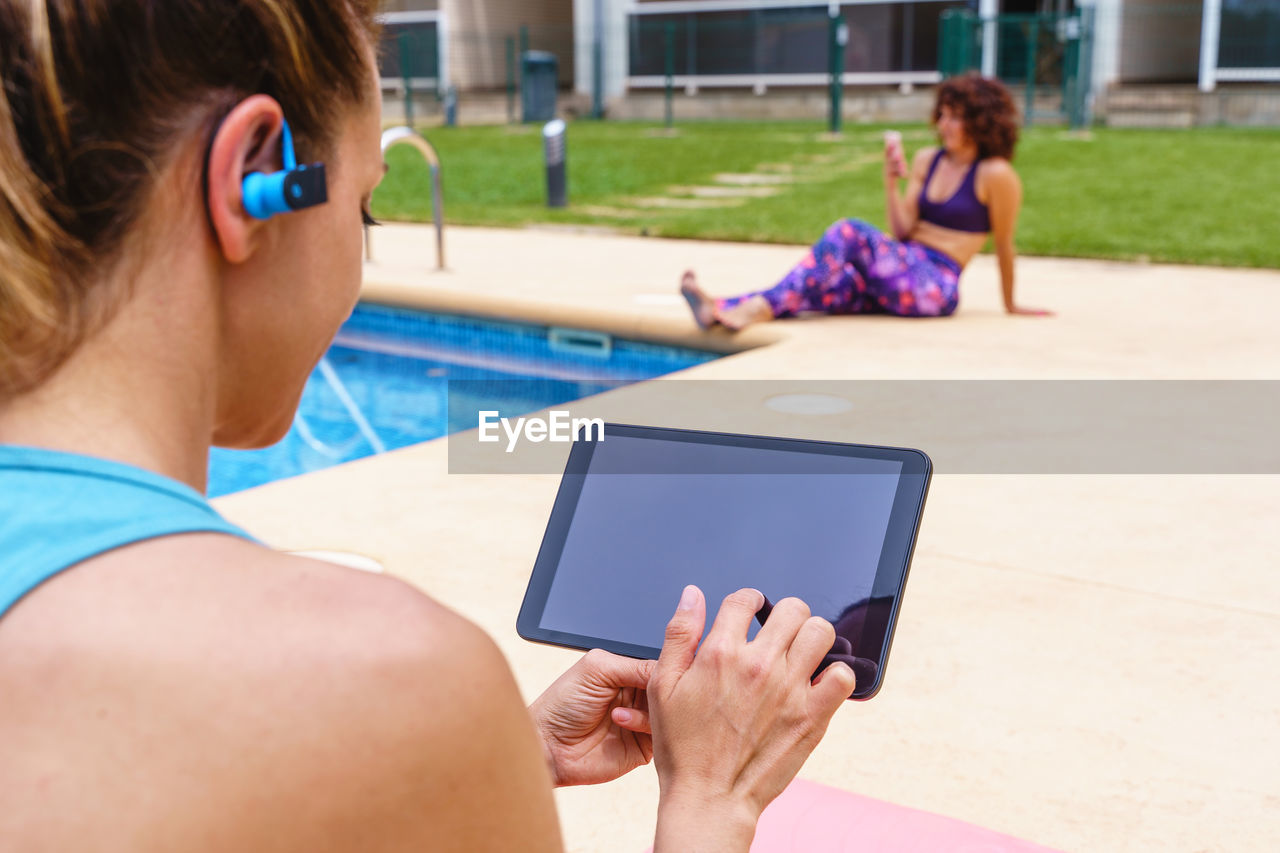 Screen mockup of fitness woman choosing an online sport class outdoors. 